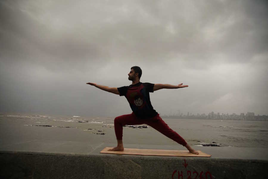 A man performs yoga along the Marine Drive promenade as he marks the first International Yoga Day, in Mumbai, India on June 21, 2015. (Sherwin Crasto/SOLARIS IMAGES)