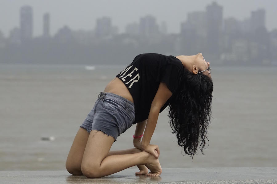 A young girl performs yoga along the Marine Drive promenade as she marks the first International Yoga Day, in Mumbai, India on June 21, 2015. (Sherwin Crasto/SOLARIS IMAGES)
